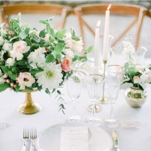 Wedding table with classic cutlery and plate and modern flowers and candles.