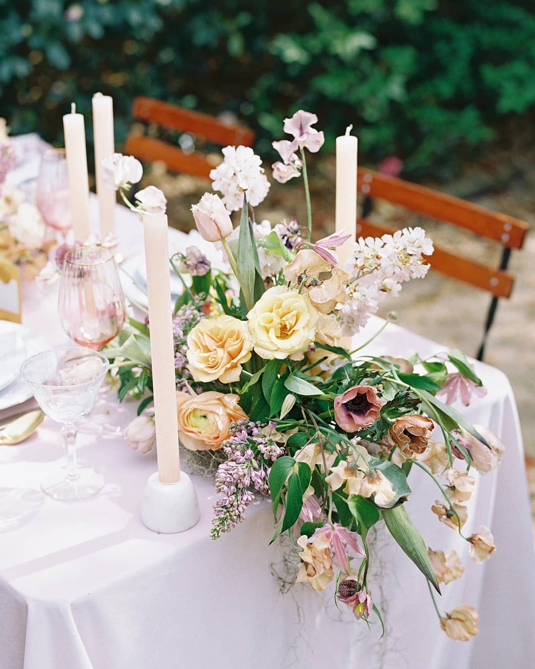 spring wedding tablescape with garden flower centerpieces, textured pink taper candles and rose glassware