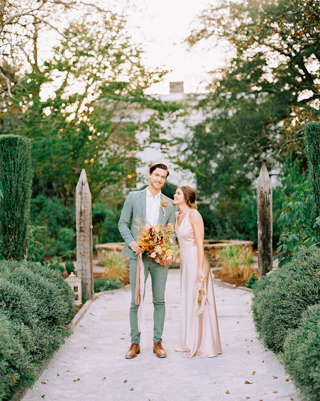 sage green groom suit and apricot silk wedding dress couple portraits in fall