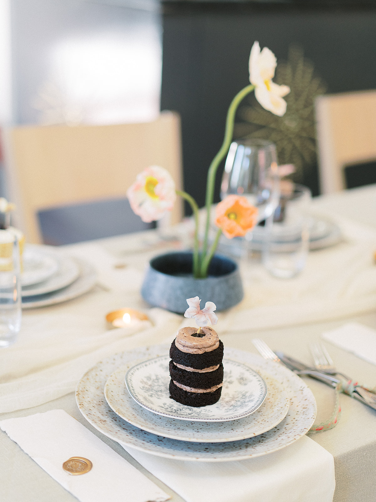 Miniature naked cake topped with a sugar flower at an intimate Charleston wedding dinner at Parcel 32, with Icelandic poppy ikebana centerpieces, speckled dinnerware, handwritten manus, vintage jacquard ribbon and soft candlelight; styling by Willow and Oak Events with photography by Kylee Yee