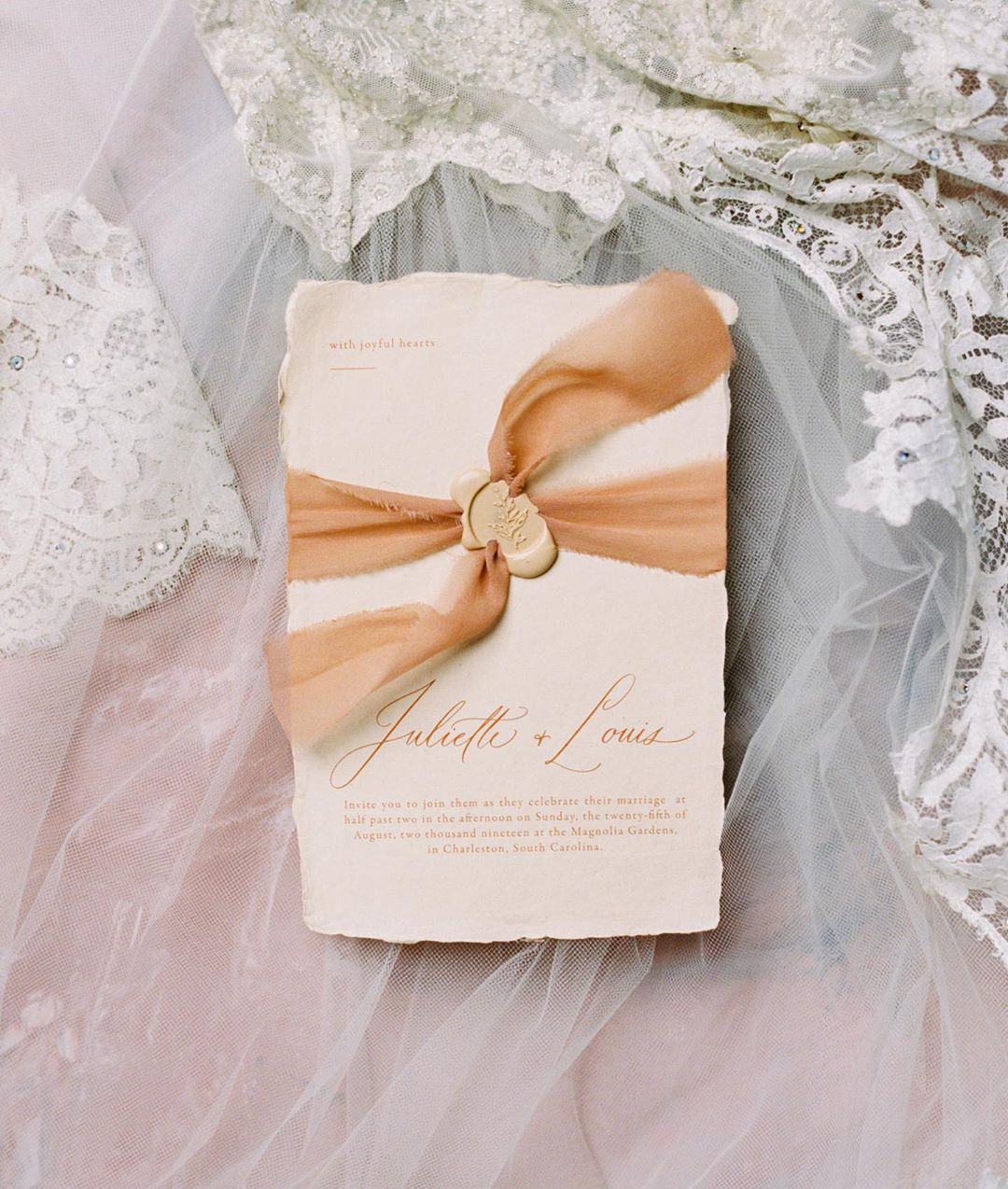 Modern romantic wedding invitations with minimalist fonts, a peach gossamer ribbon and melted wax seal by Dominique Alba | Styling by Willow and Oak Events and photography by Brian D Smith Photography