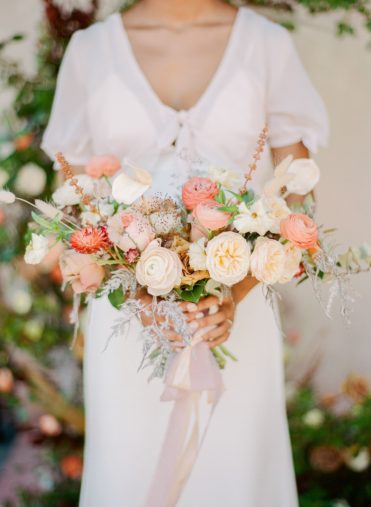 Peach and coral bridal bouquet with trailing silk ribbon from a midsummer wedding designed by Willow & Oak Events, captured by Charleston wedding photographer, Clay Austin