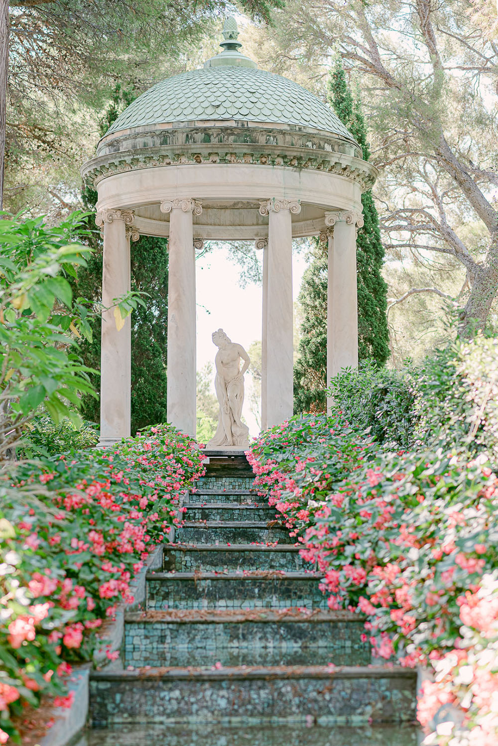 The gardens of Villa Ephrussi de Rothschild with a marble sculpture in a columned pavilion