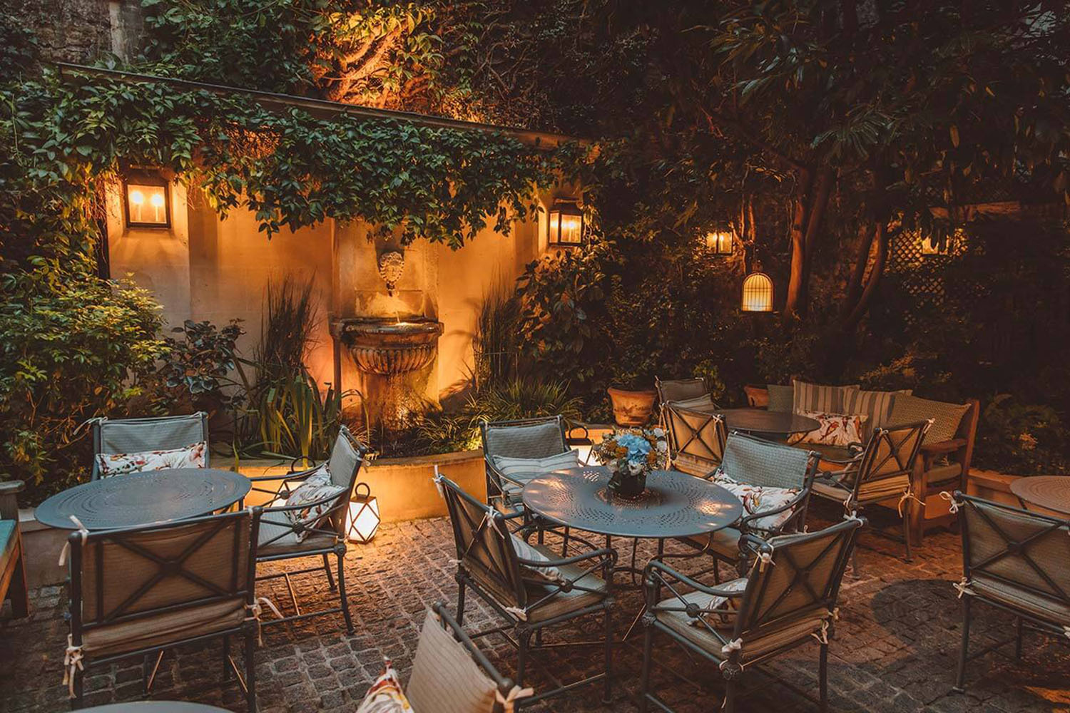 The courtyard garden restaurant of Hôtel de l'Abbaye at night, with warm lanterns to set the mood