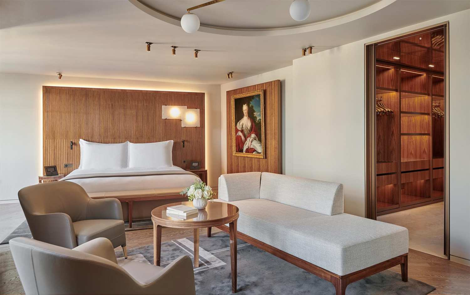 Contemporary white furniture and handcrafted woodwork throughout one of the guest rooms at Hotel Lutetia