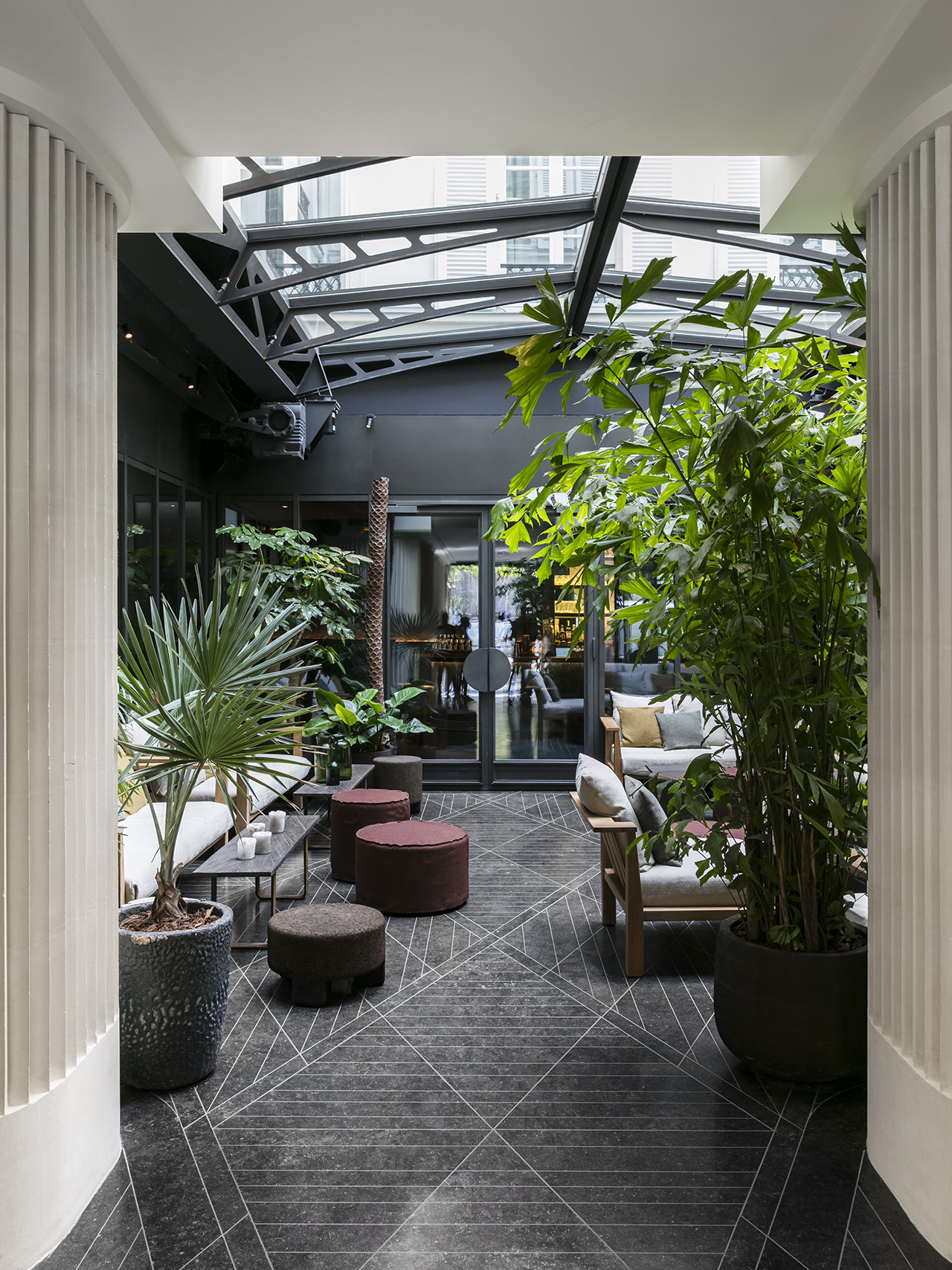 The gray-stone floored lobby with red and brown furniture at Hôtel National des Arts et Métiers