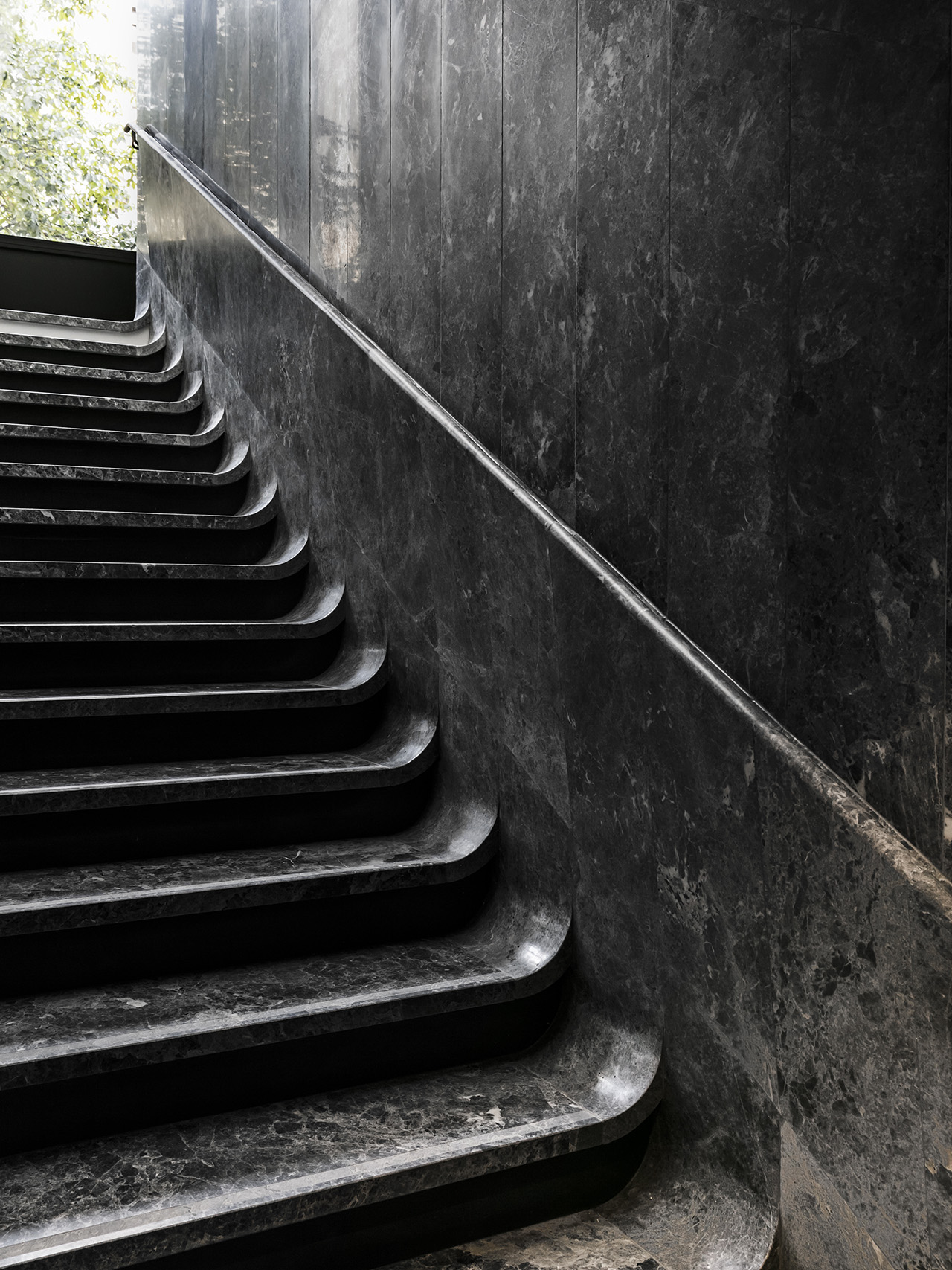 The sculpted staircase with a floating effect for the glossy black marble material at Hôtel National des Arts et Métiers