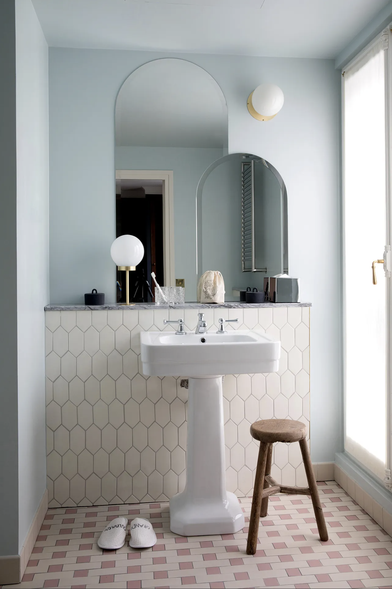A salmon and cream ceramic tiled bathroom with layered domed mirrors in two sizes and modern orb lighting at Hotel des Grands Boulevards