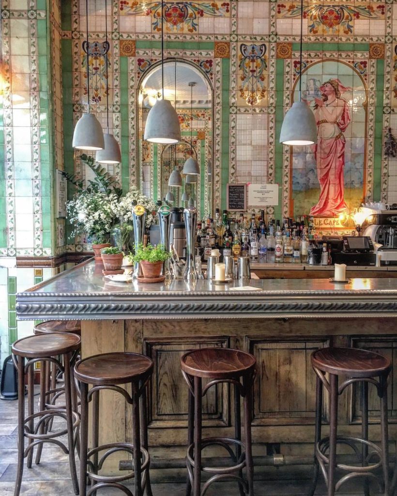 Belle Epoque interiors and Art Nouveau mosaic bar backdrop at Poulette 