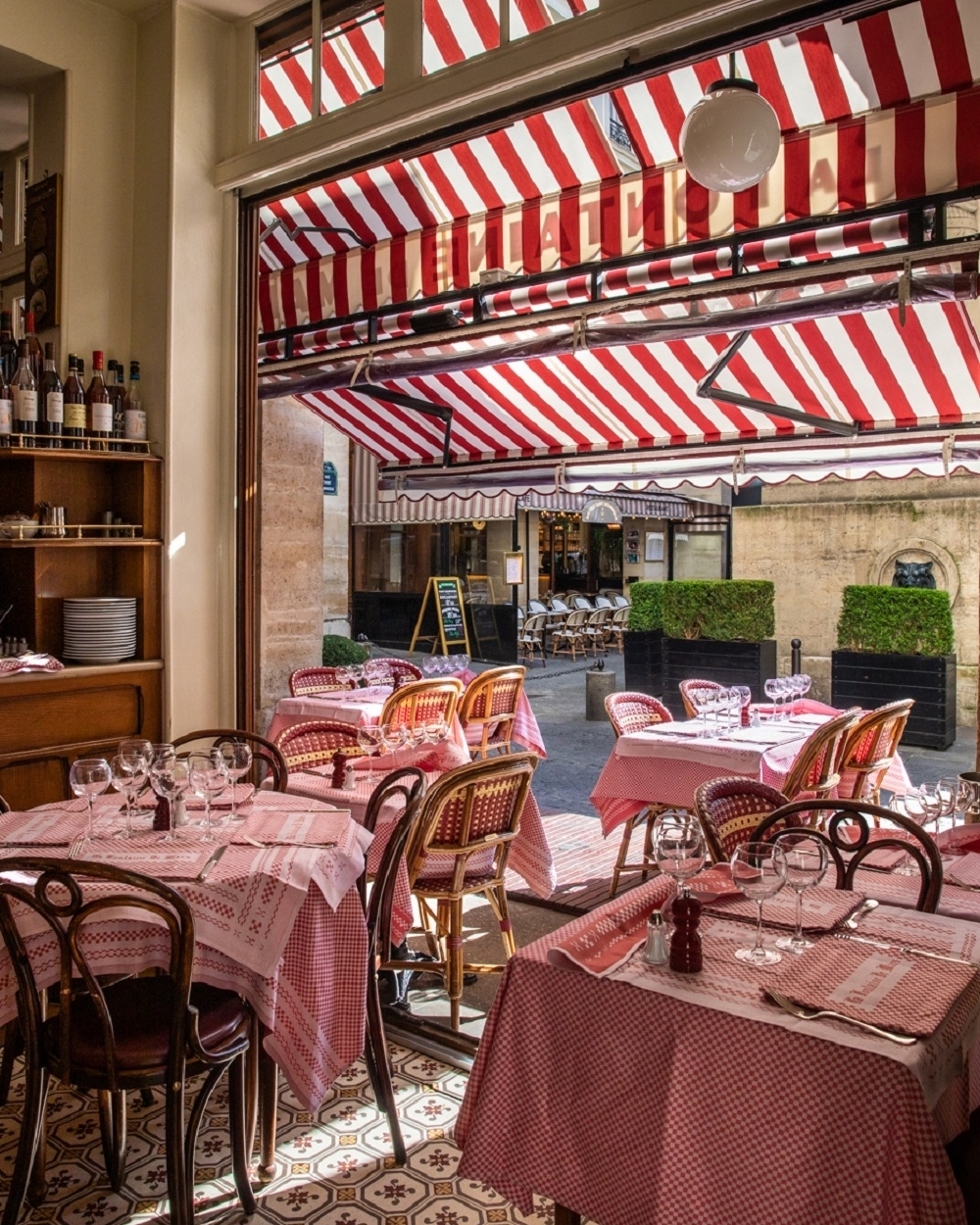 Checkered red table linens and red woven bistro chairs at La Fontaine de Mars