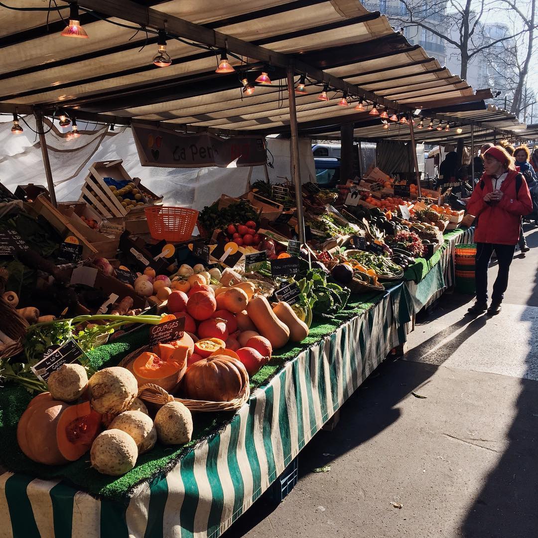 Fresh produce filling entire market stalls at Marché Raspail in Paris